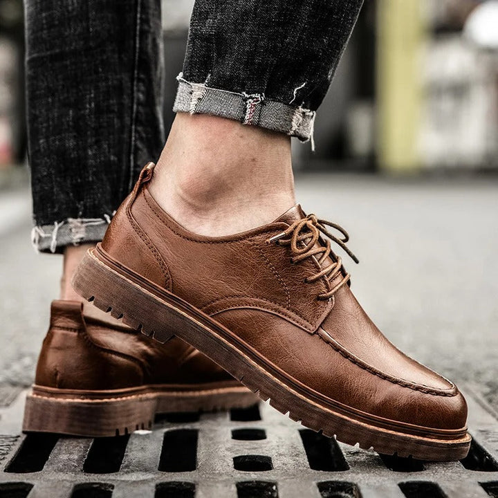 Pair of men's low-cut black leather loafers, versatile for casual outfits & dressy occasions.