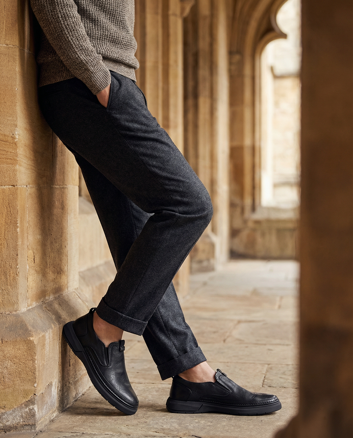 Side view of durable men's black leather slip-on shoes, everyday footwear