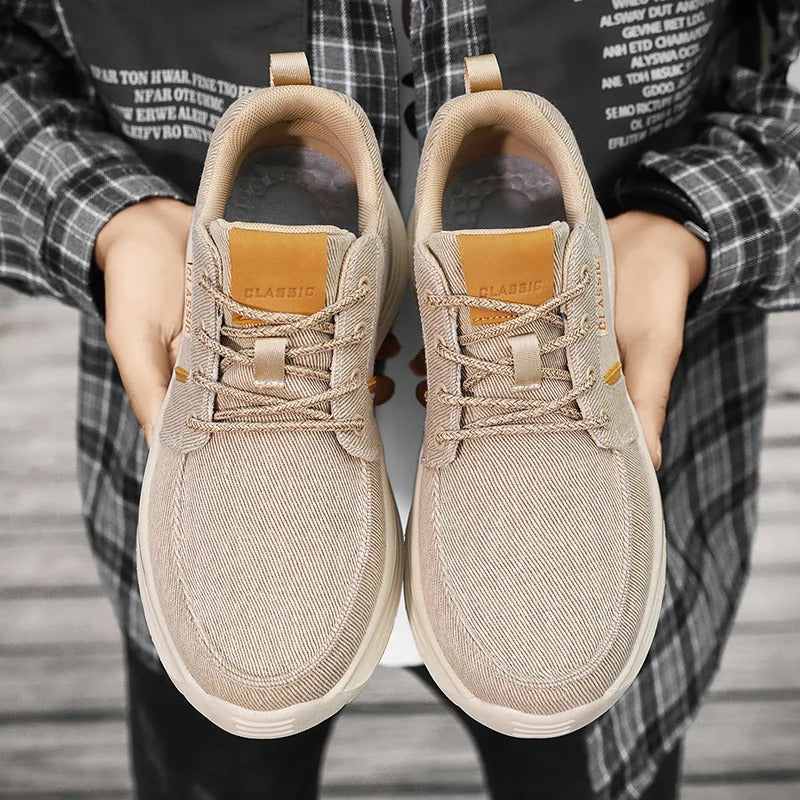 Side view of men's blue canvas comfort sneakers, featuring a moc toe design and lightweight sole.