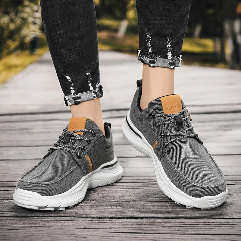 Man wearing men's gray canvas comfort sneakers, demonstrating everyday style and comfort.
