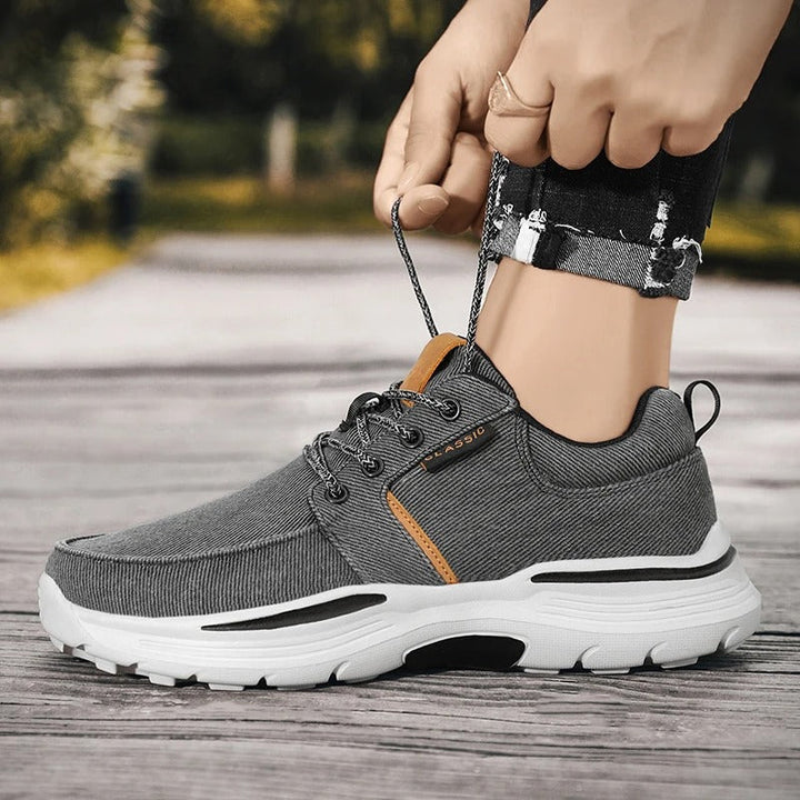 Detail of the moc toe stitching on men's blue canvas comfort sneakers, a classic casual design.