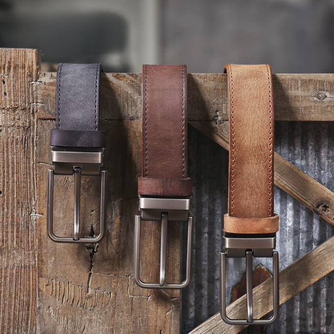Close-up of a men's black full-grain leather belt with a sleek, simple buckle