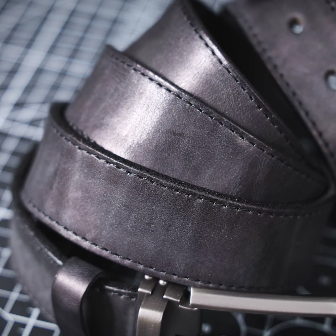 Side view of a men's black full-grain leather belt, showcasing its durability