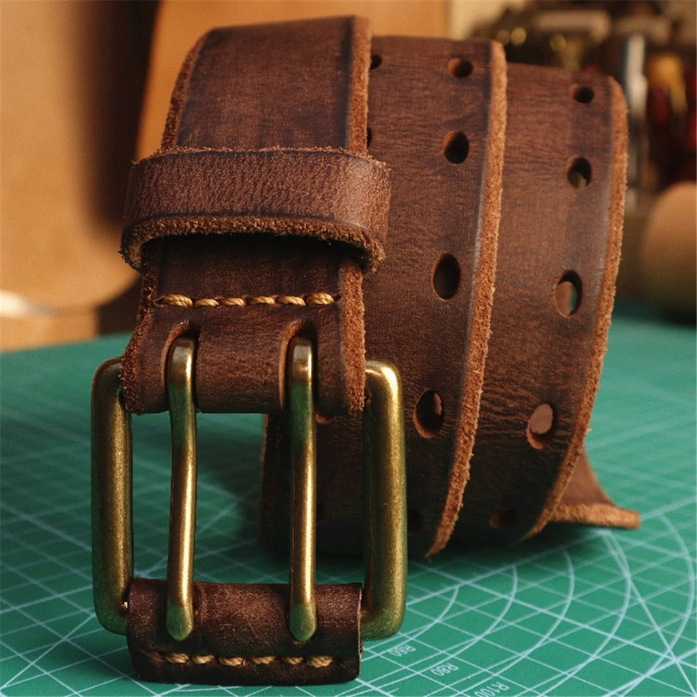 Close-up of a men's full-grain leather belt, showcasing the durable double-prong buckle design.