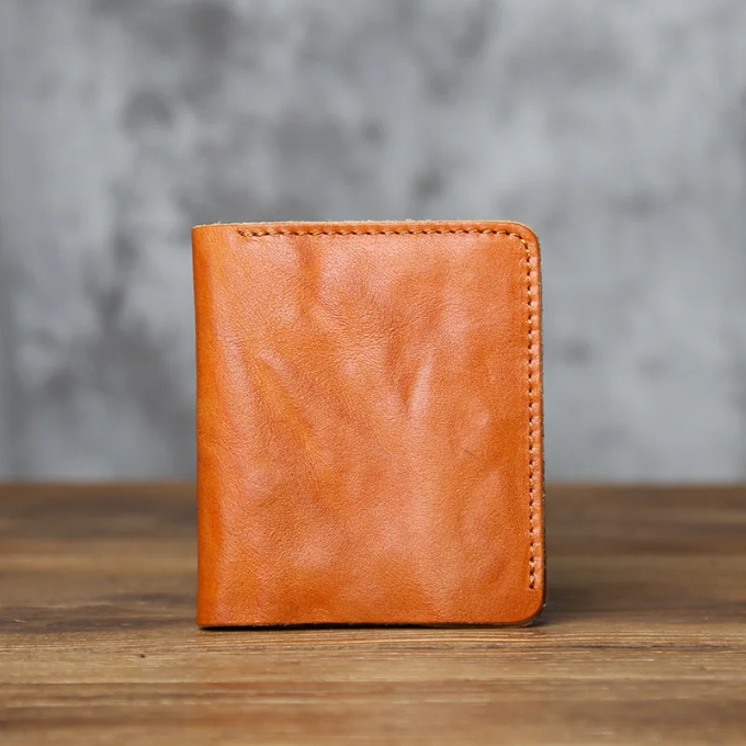 Open view of a men's full-grain leather bi-fold wallet, showing card slots and currency well.