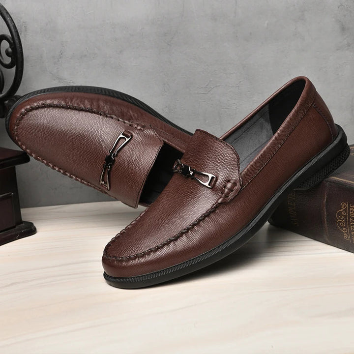 Durable men's slip-on leather loafers, showcasing the quality craftsmanship and elegant metal detail.