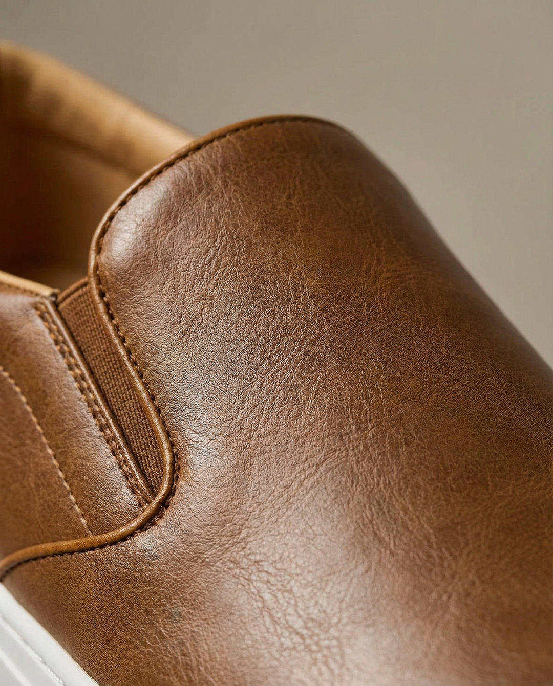Side view of a men's brown genuine leather slip-on shoe, emphasizing the sleek design and easy wearability.