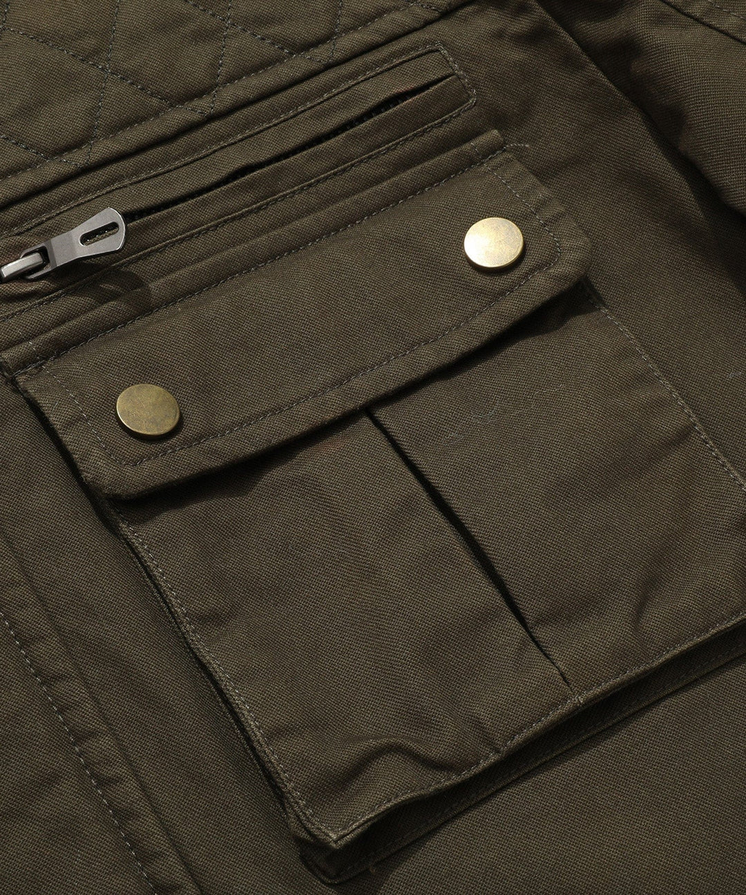 Detail of the robust zipper and snap closures on a men's quilted field jacket.