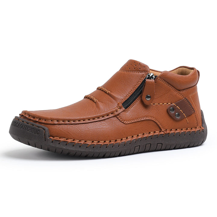 Close-up of the intricate hand-stitching on the side of men's high-top orthopedic leather boots.
