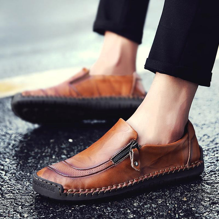 Close-up of men's leather slip-on loafers, detailed hand-stitching & functional zipper