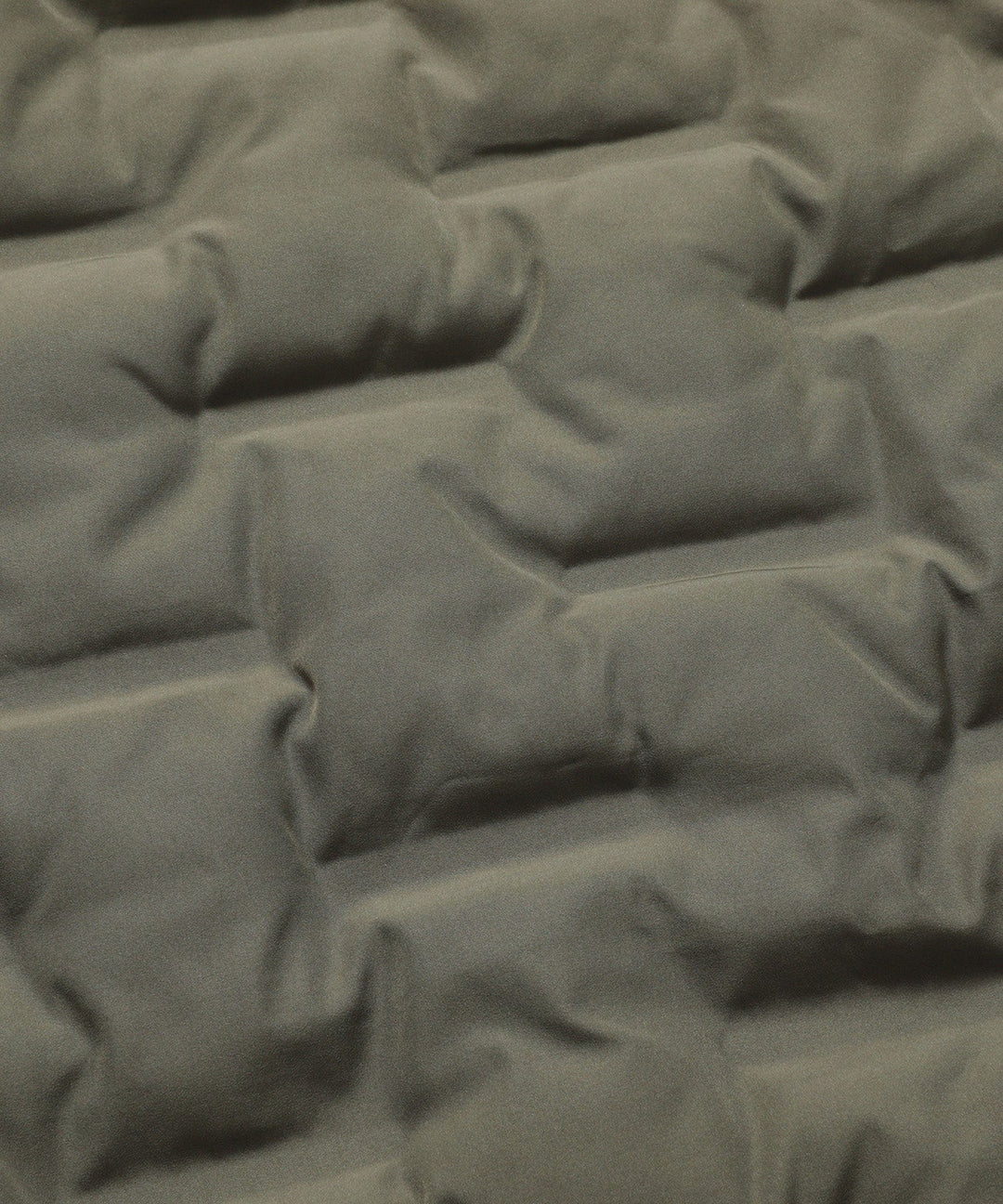 Angled view of a men's insulated army green bomber jacket, showcasing its modern puffer aesthetic.