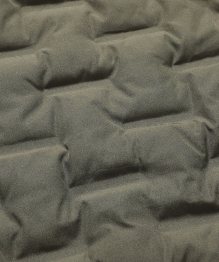 Angled view of a men's insulated army green bomber jacket, showcasing its modern puffer aesthetic.