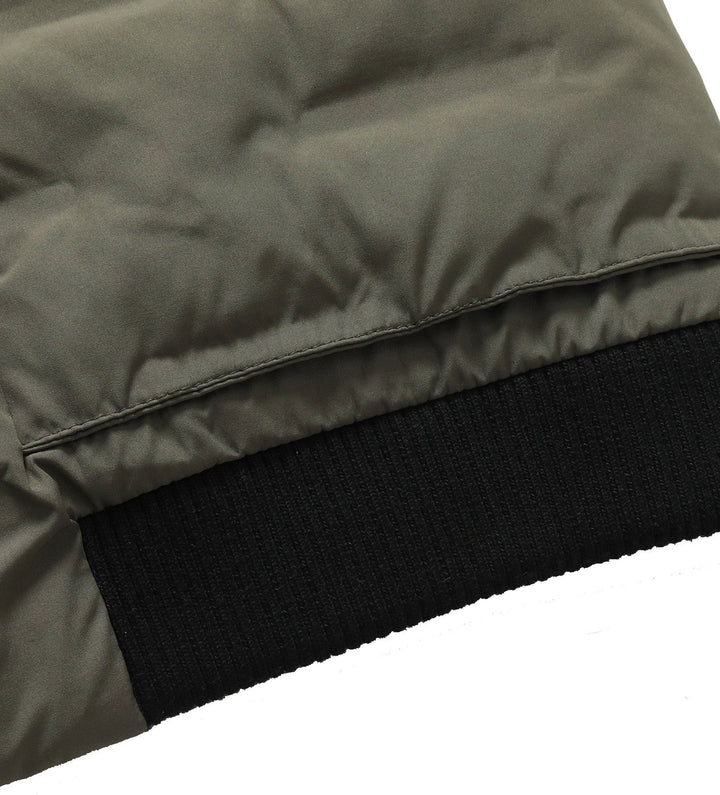 Detail of the ribbed cuffs and hem on a men's bomber jacket, adding to its classic puffer style.