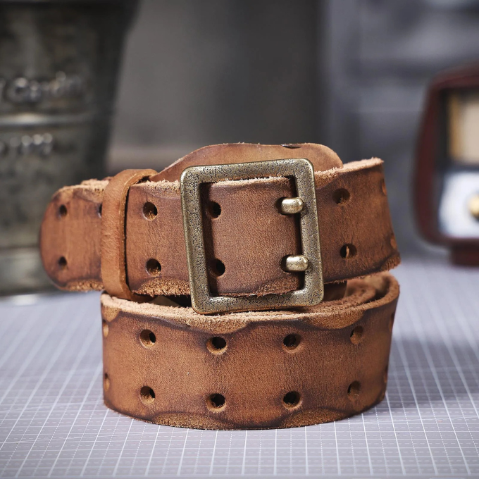 Close-up of a men's rugged Italian leather belt showcasing the distressed texture and sturdy brass buckle.