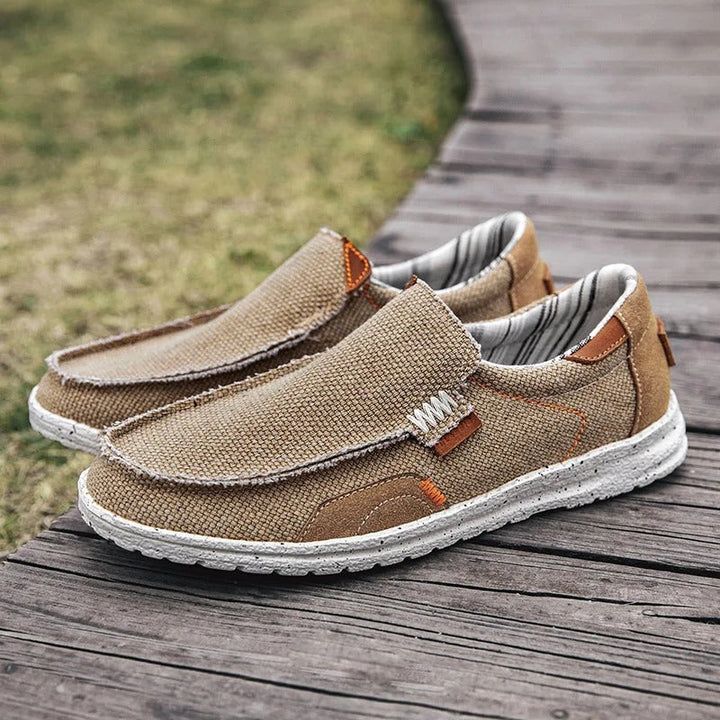 Overhead shot of three pairs of men's canvas slip-on shoes (khaki, blue, gray)