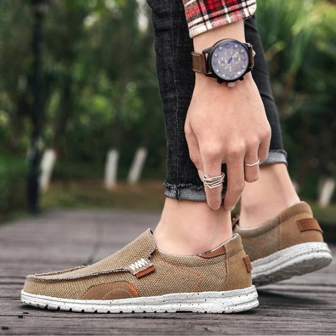 Men's khaki canvas slip-on shoes on a wooden floor, accentuating comfort