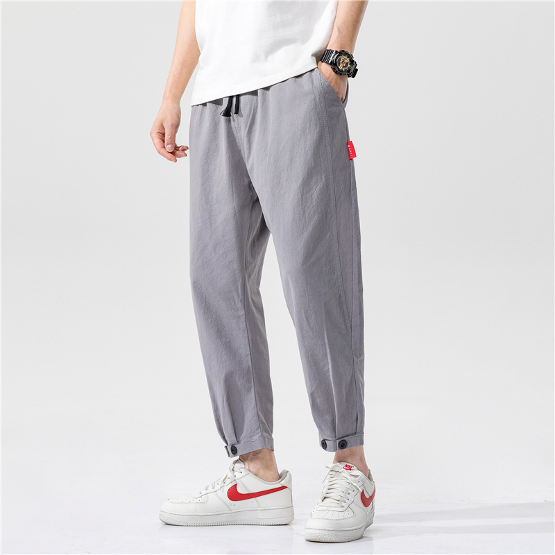 Man wearing khaki linen blend tapered cropped trousers, showcasing the fit and style