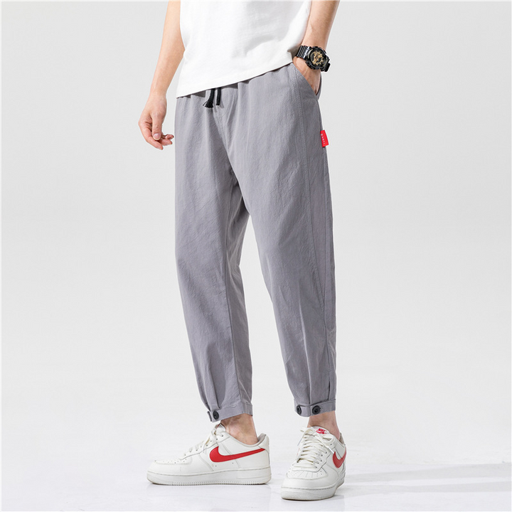 Man wearing khaki linen blend tapered cropped trousers, showcasing the fit and style
