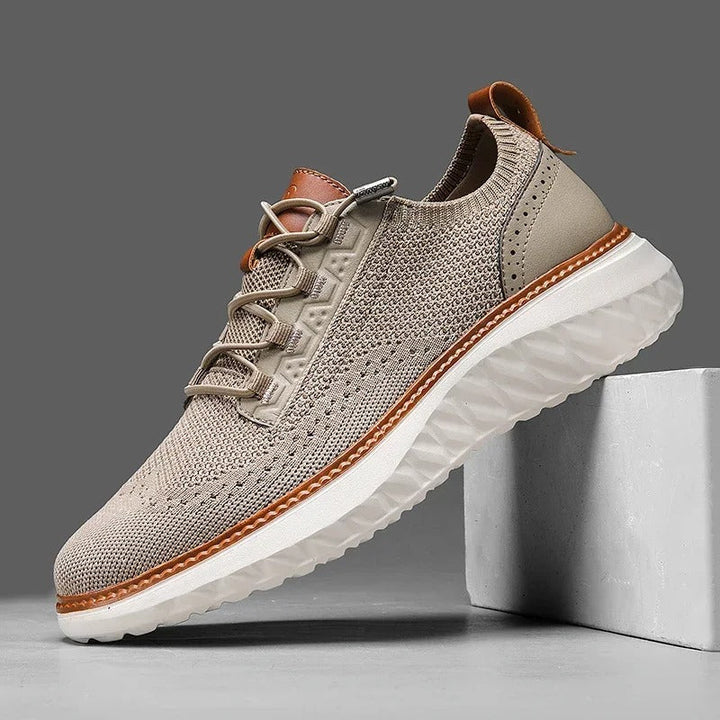 Close-up of a men's knit sneaker showing khaki textile and blue leather accents, a comfortable casual footwear.