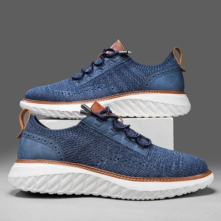 Side view of a men's khaki knit sneaker with blue leather accents, a flexible and fashionable casual shoe.