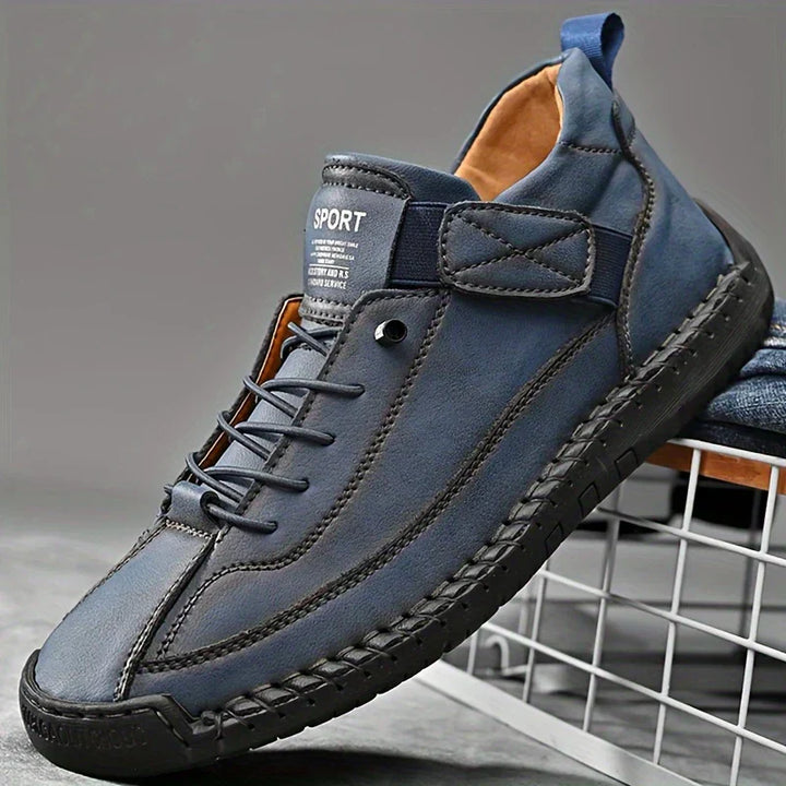 Close-up of the genuine leather texture on men's comfort orthopedic sneakers, black color.