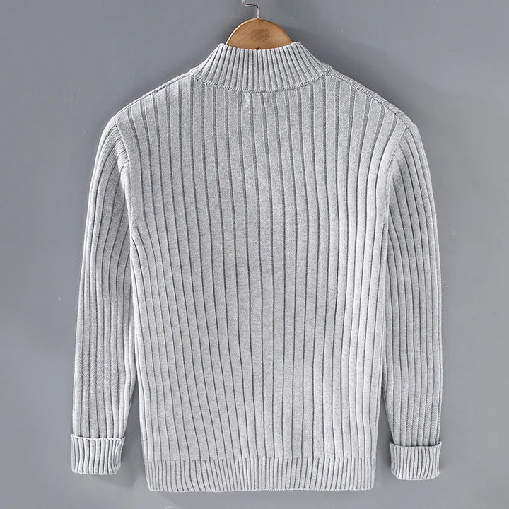 Model wearing a men's dark blue ribbed knit zip-front sweater, showing versatility and style