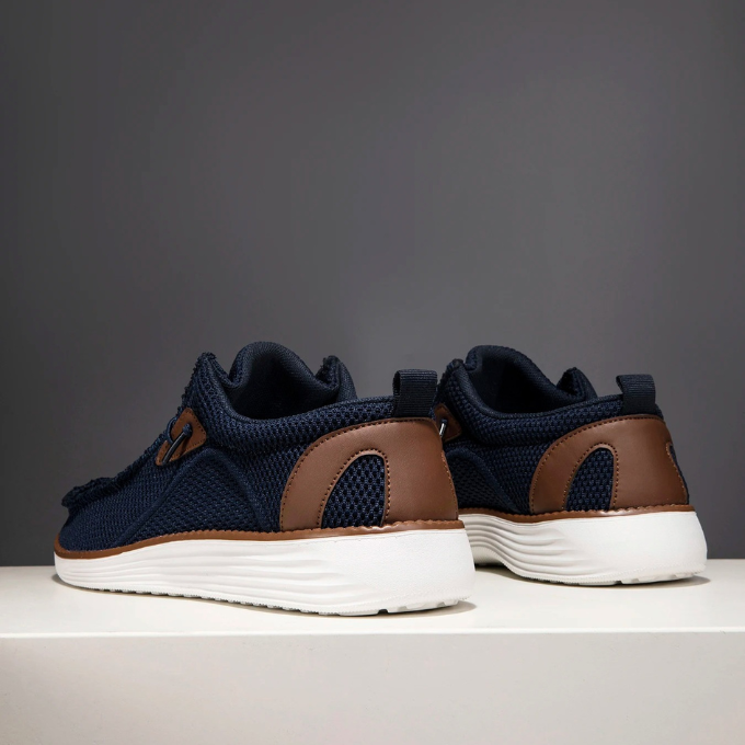 Men's loafers on a beach setting, suggesting their breathable and casual nature