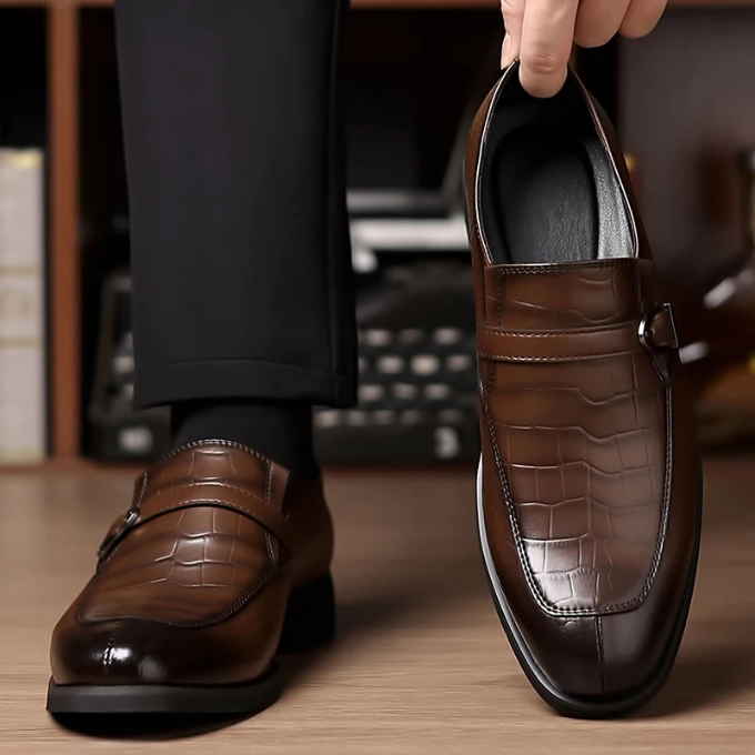 Studio shot of men's black monk strap leather loafers, emphasizing their sleek design and executive appeal.