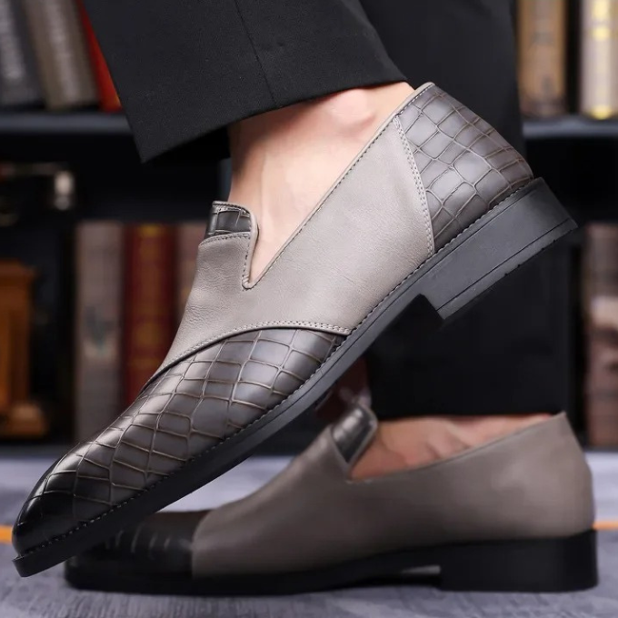 Side profile of a men's black croc-print loafer, demonstrating its sleek design