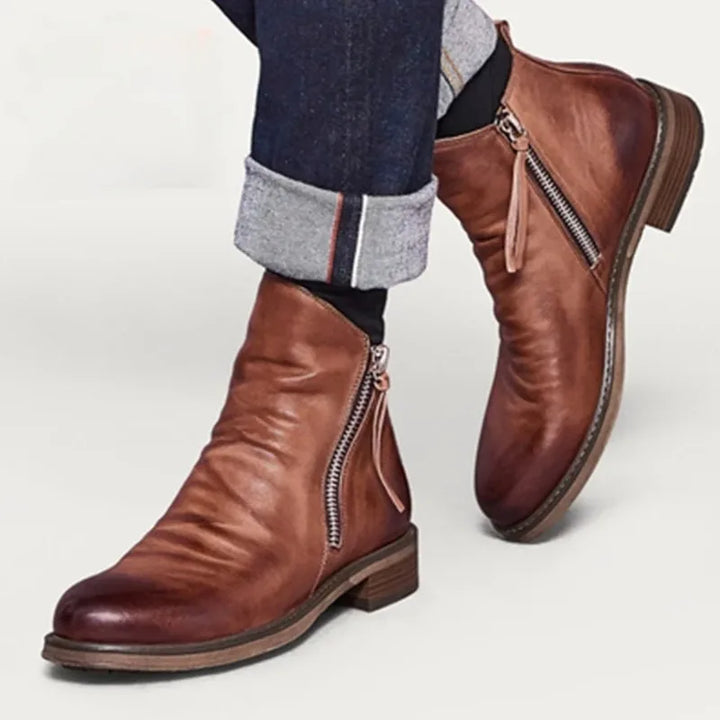 Men's modern black leather Chelsea boots, polished and sleek, for dress or casual outfits.