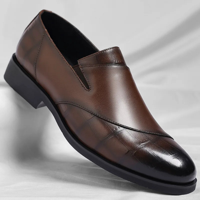 Close-up of a men's modern brown leather slip-on loafer, showing polished texture and stitching