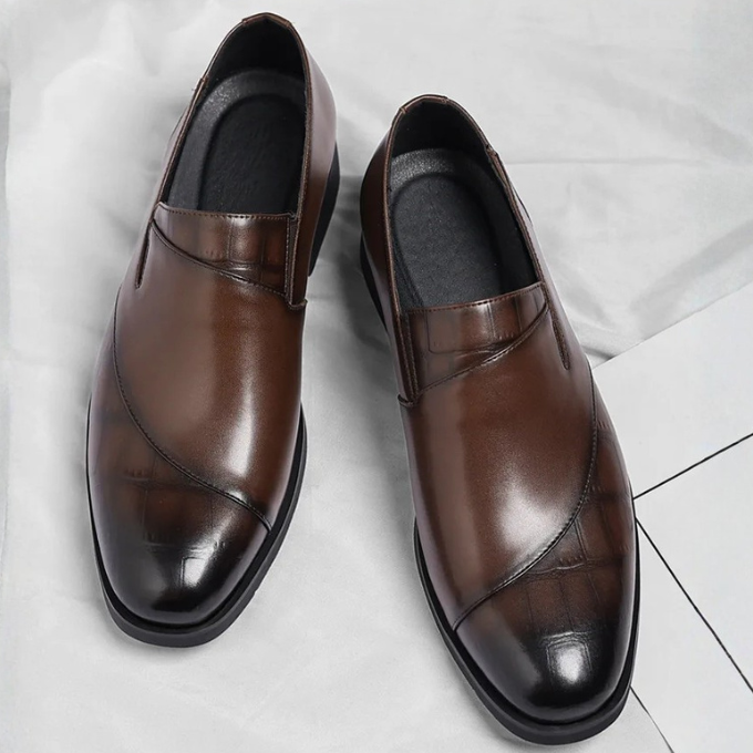 Stylish pair of men's modern leather slip-on loafers in a dark tan, perfect for smart casual looks