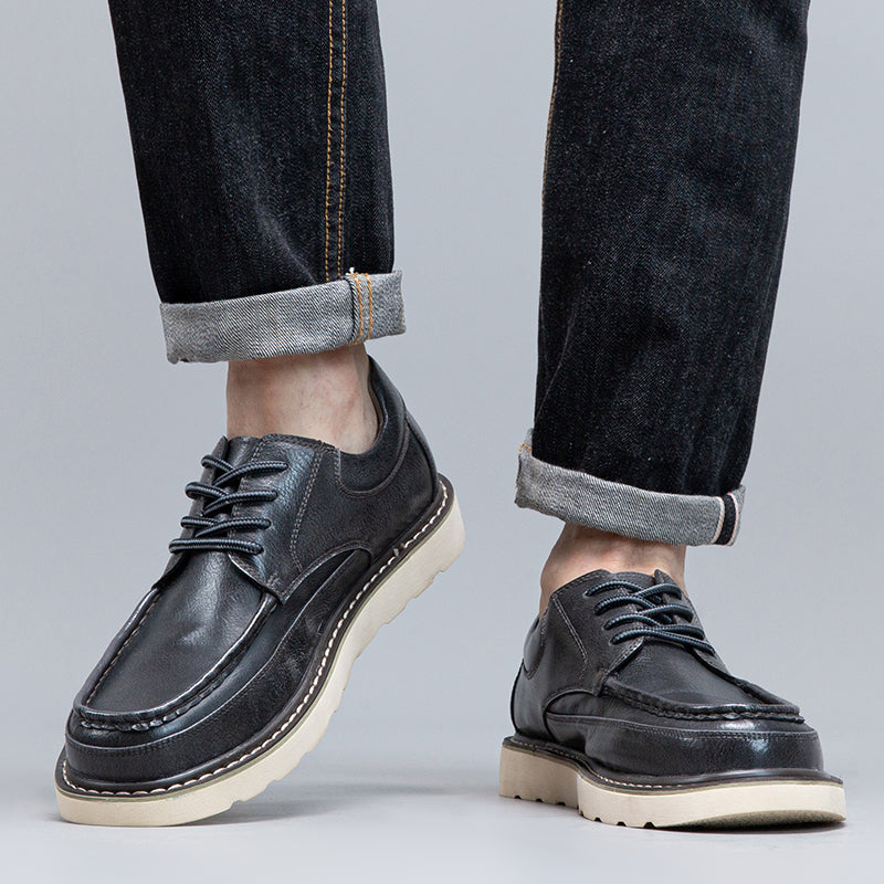 Men's grey casual boots on a cobblestone path, highlighting their durable design