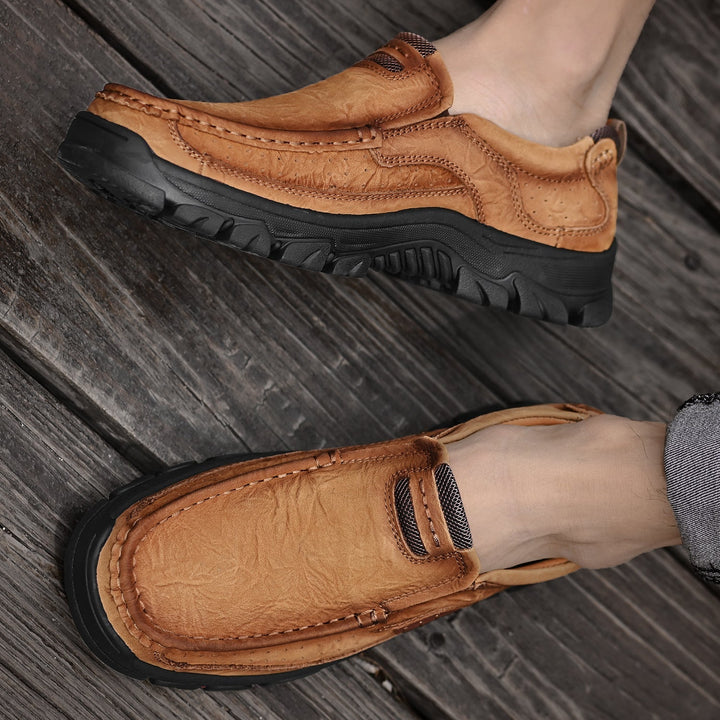 Overhead shot of brown orthopedic men's boots, comfortable soles prominent, ready for wear.