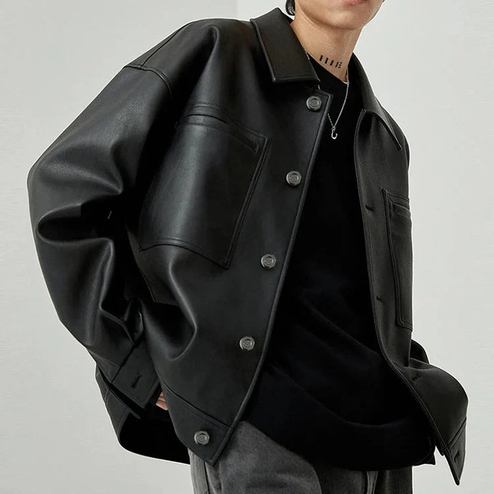 Men's oversized faux leather jacket in black, draped casually, showcasing its comfortable fit and style