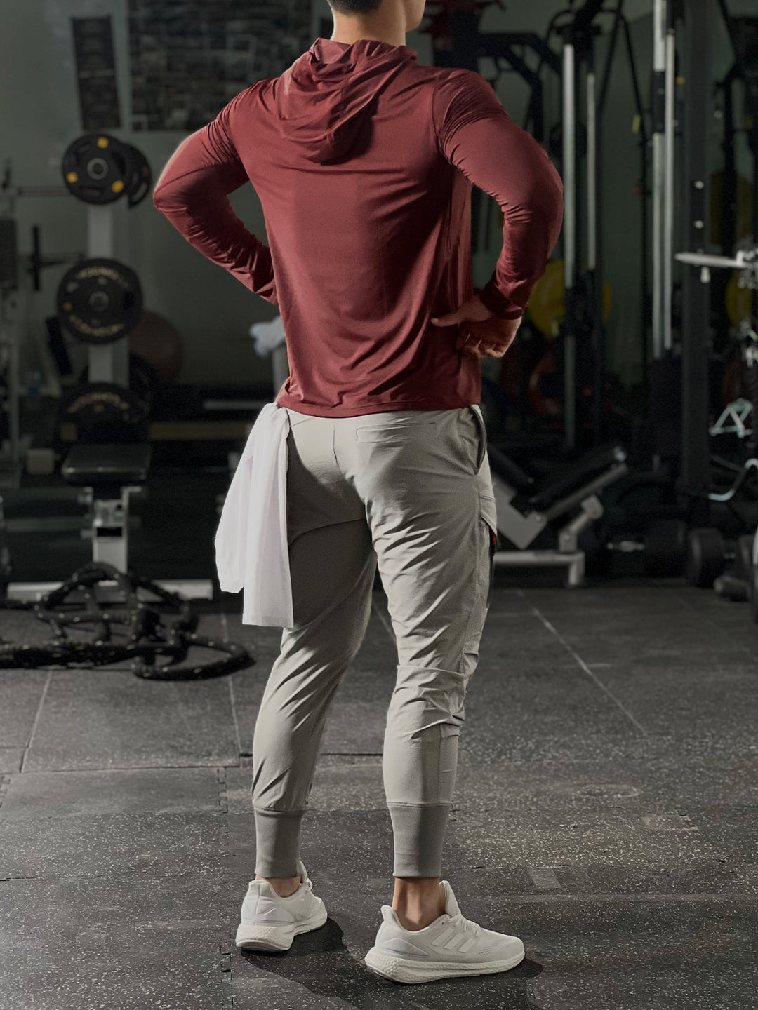 Stack of folded men's performance baselayer hoodies in various colors, ready for gym wear