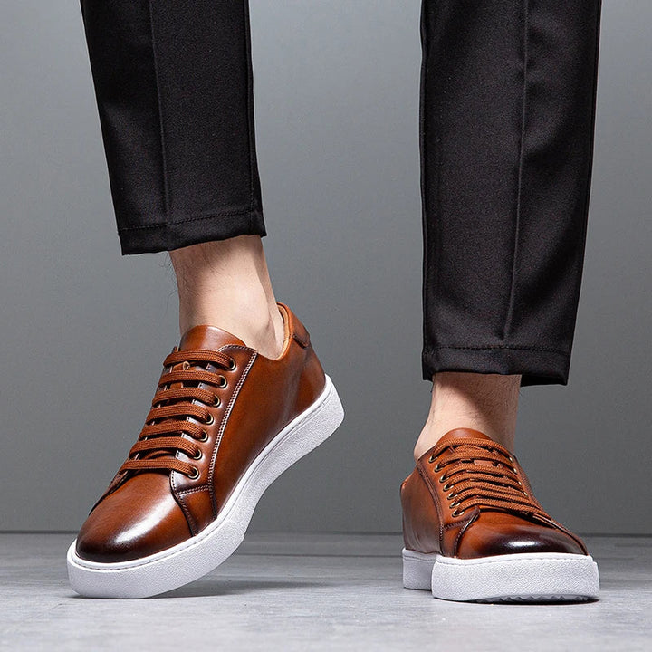 Three pairs of men's leather sneakers in various colors: brown, black, & white