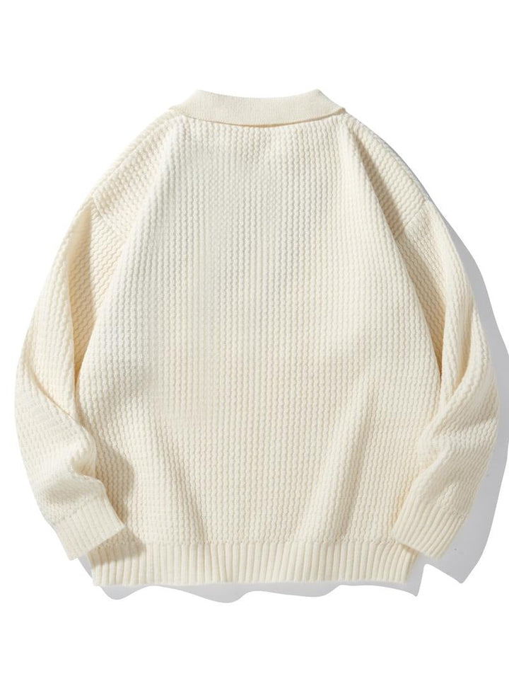 Close-up of a men's premium knit polo sweater, showcasing the intricate waffle weave and soft fabric.