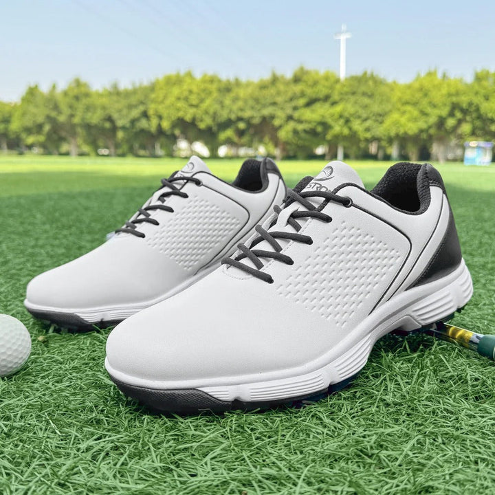 Men's blackout golf shoes with blue highlights, performance spikes, & water-resistant leather.