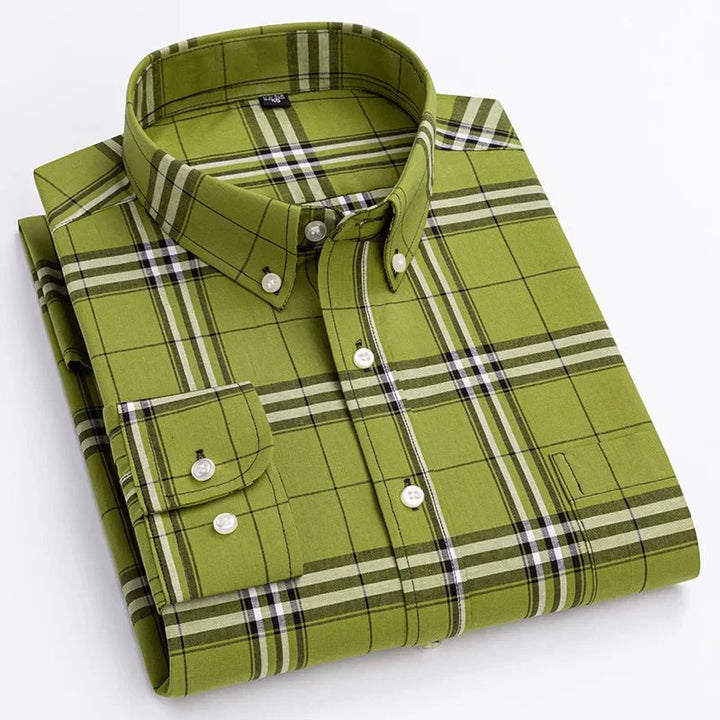 Fashion shot of a man wearing a brown plaid long sleeve button-down shirt, styled casually with jeans.