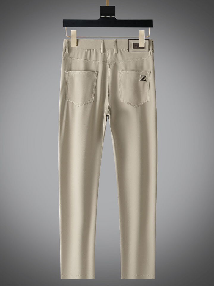 Model wearing men's beige matte trousers, styled for a contemporary and refined appearance.