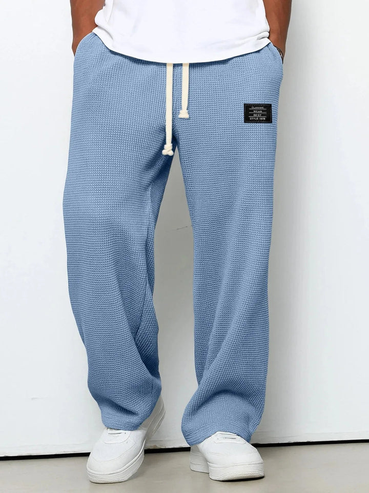 Men's relaxed fit blue lounge pants, waffle knit for ultimate comfort & everyday casual style. Drawstring waist.