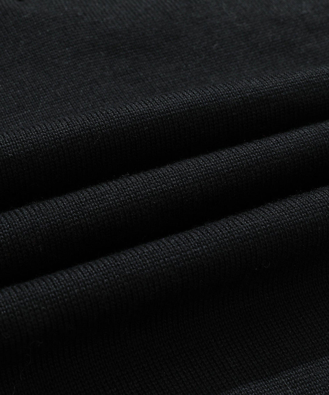 Detail of the half-zip closure on a men's black mock neck sweater, adding modern touch