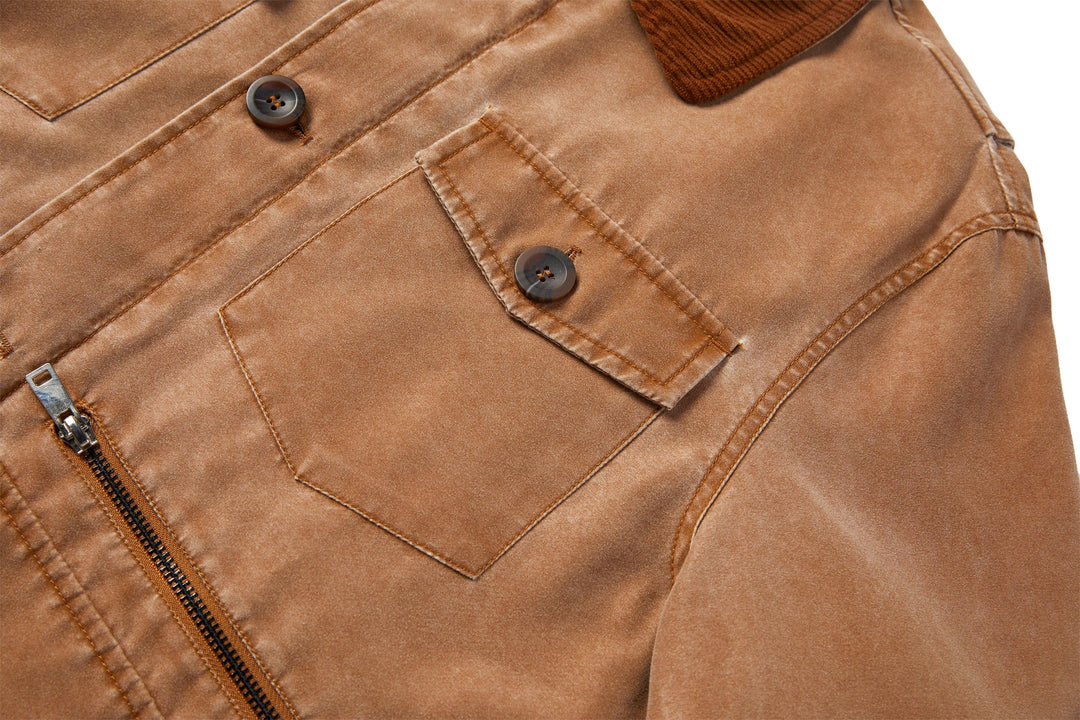Zipper and button closure details on the black canvas utility jacket with a corduroy collar.