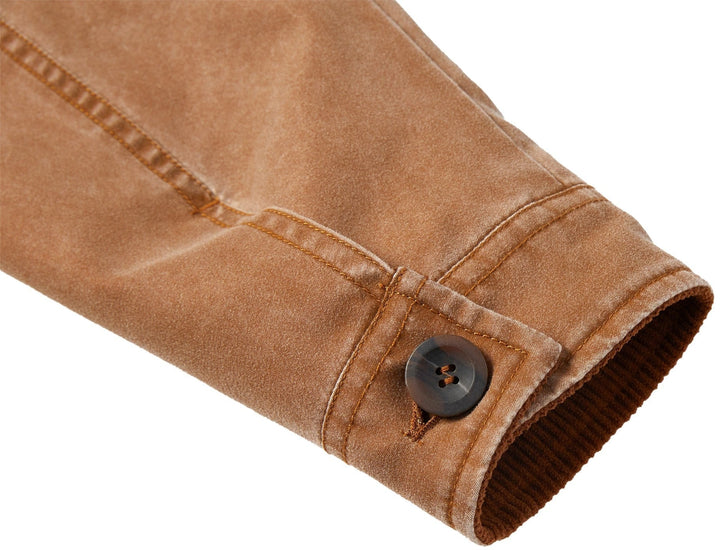 Close-up of the brand logo or tag on a black canvas utility jacket, emphasizing authenticity.