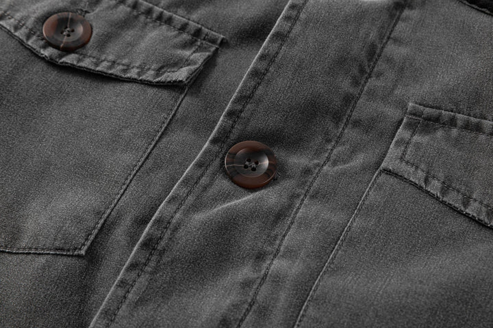 Close-up of the durable canvas fabric of the men's black jacket, with contrasting corduroy collar.