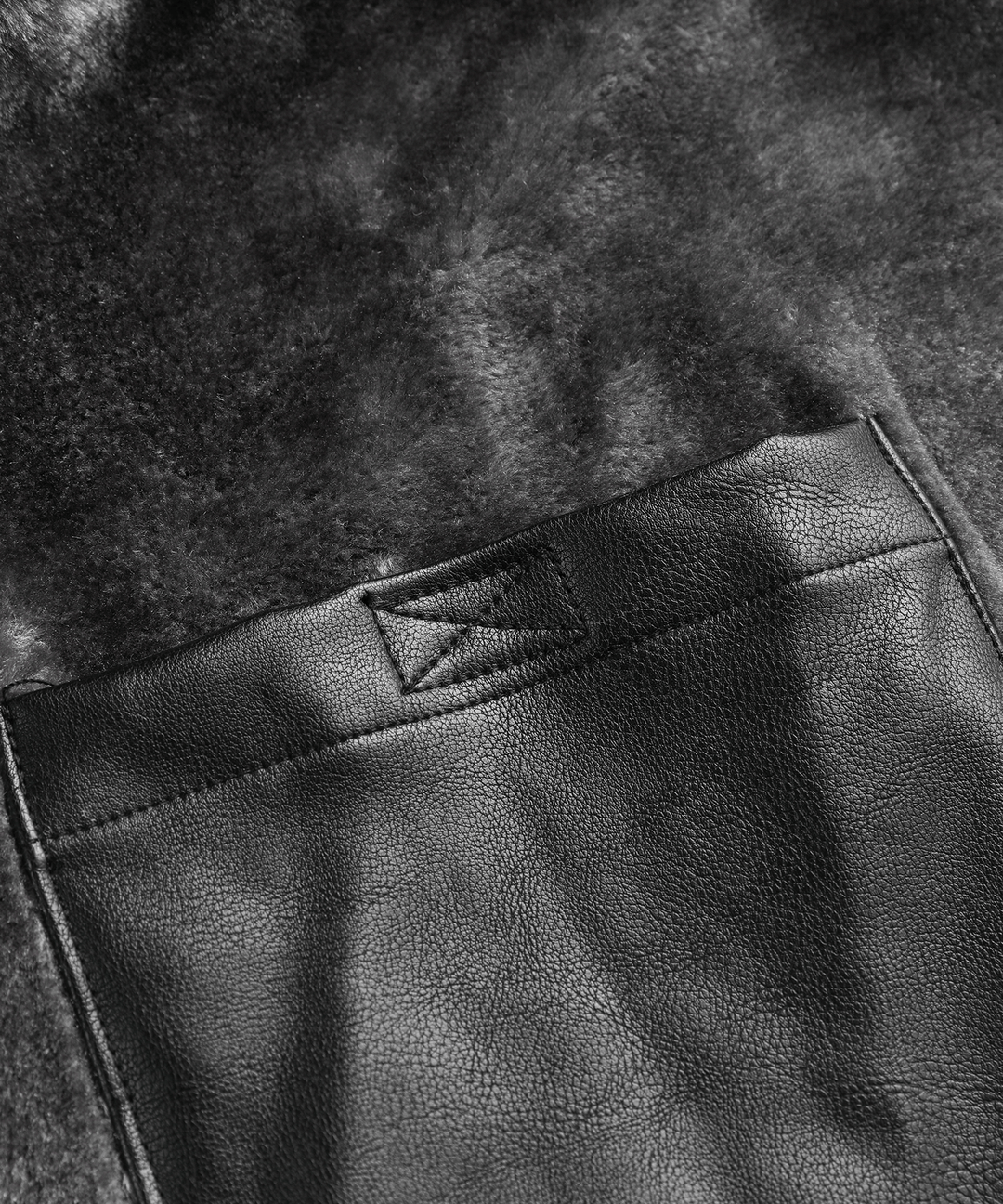 Detail of the high collar and durable zipper on the men's rugged black winter jacket