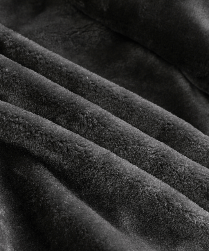 The rugged men's arctic winter coat with its hood up, providing extra cold weather protection
