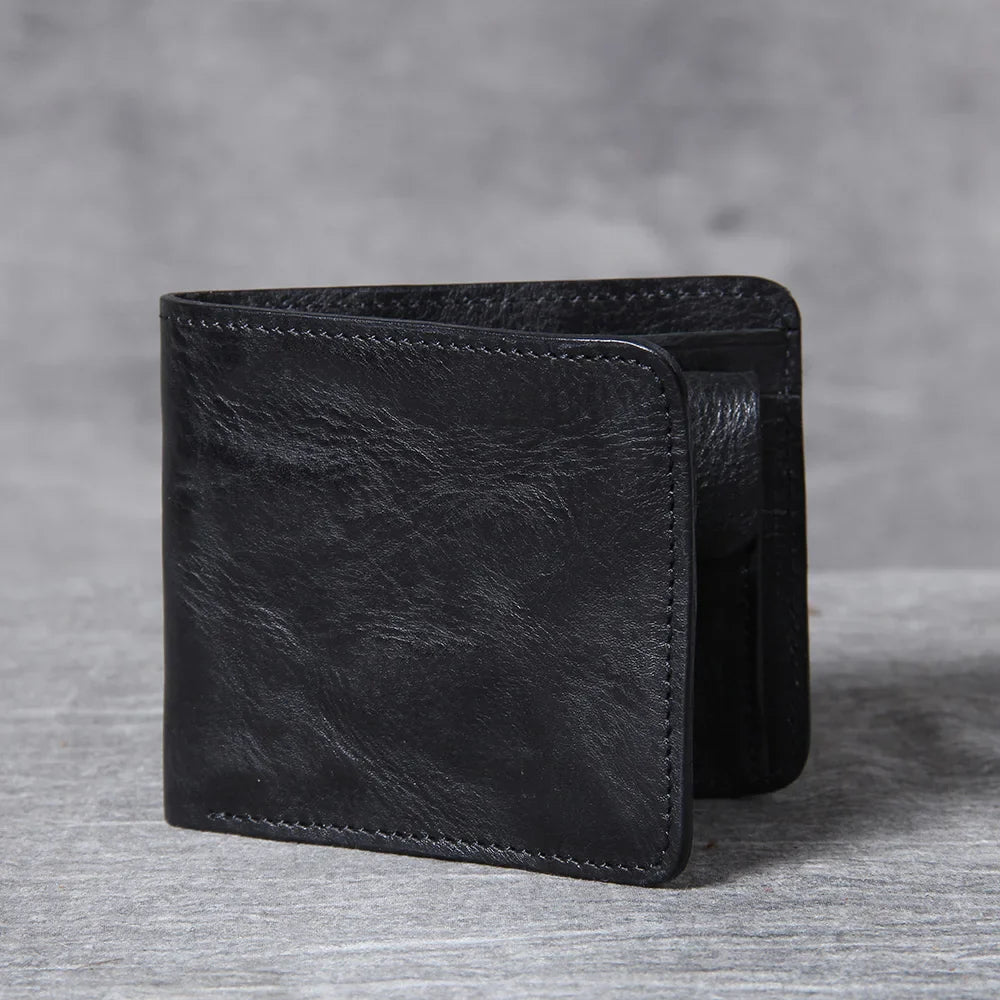 Hand holding a men's cowhide leather bifold wallet, demonstrating its ergonomic fit.