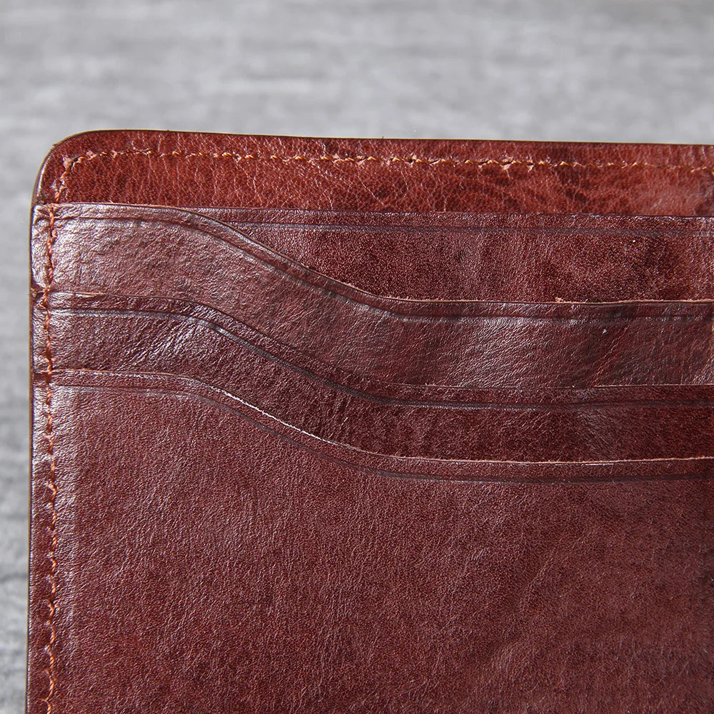 Close-up of the textured genuine cowhide leather on a men's slim bifold wallet.